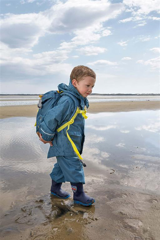 foto de un niño llevando una mochila lässig
