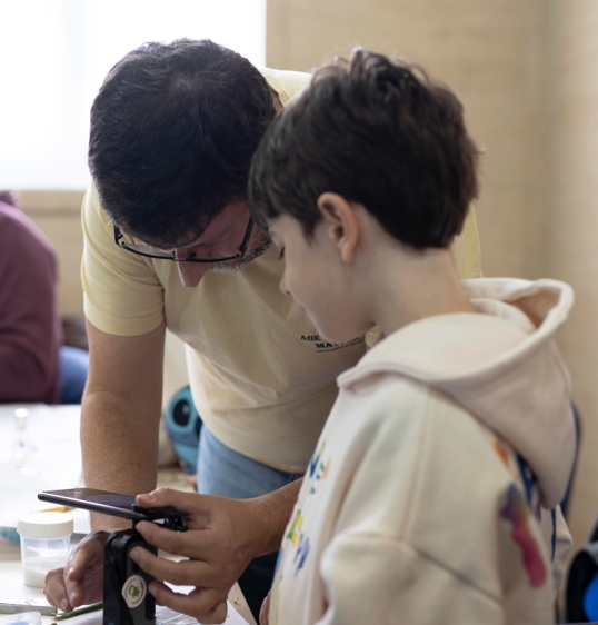 Profesor y alumno observan con un microscopio